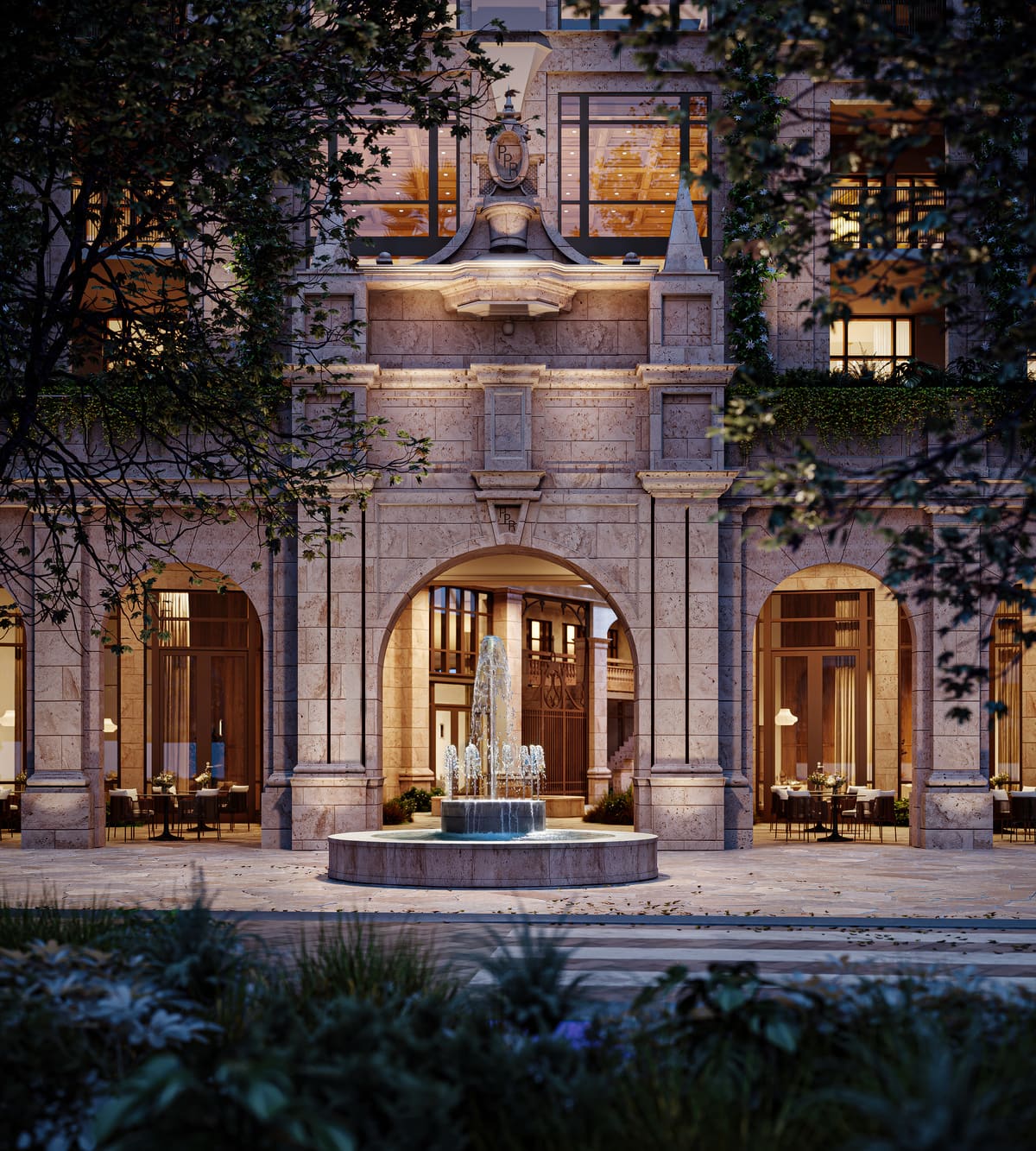 The arched south entrance to Ponce Park Residences, with a stone fountain set between the arcade openings