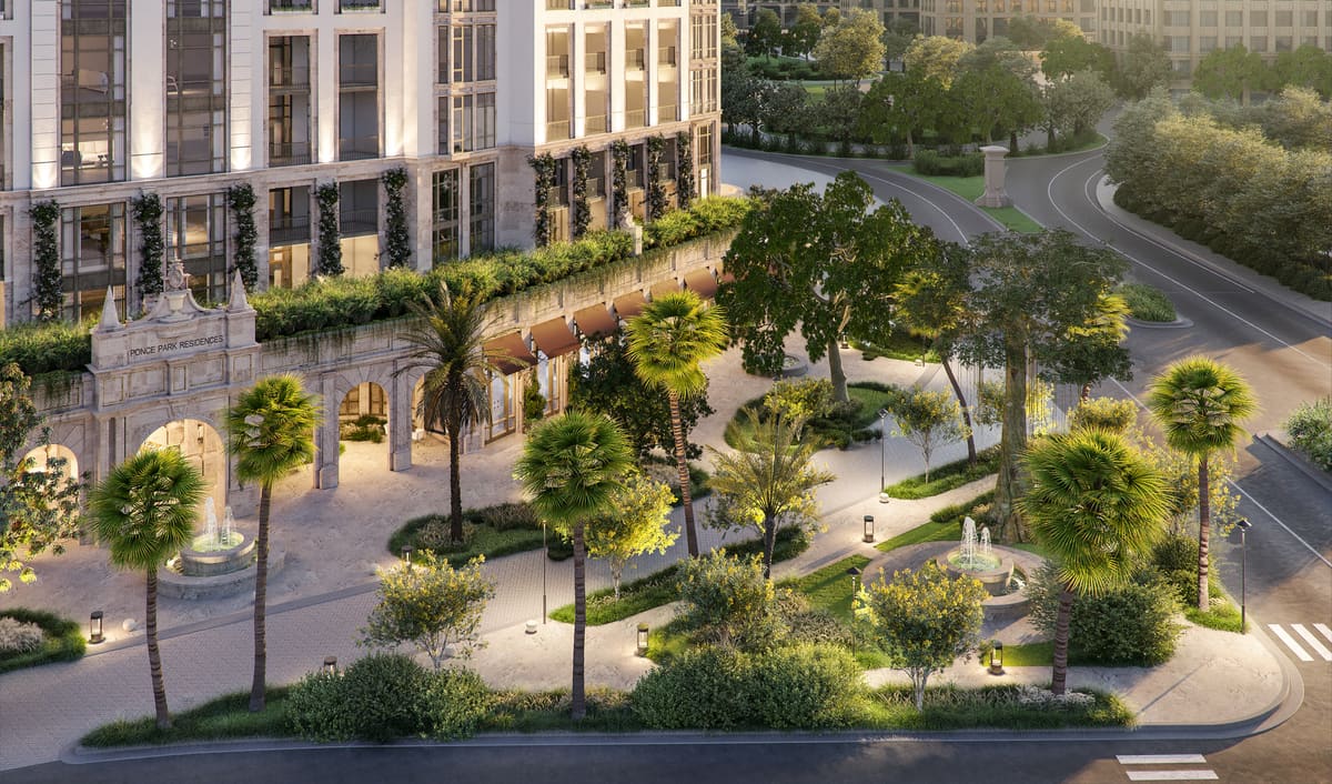 Ponce Park Residences seen across the landscaped park, with palms and fountains along the paseo