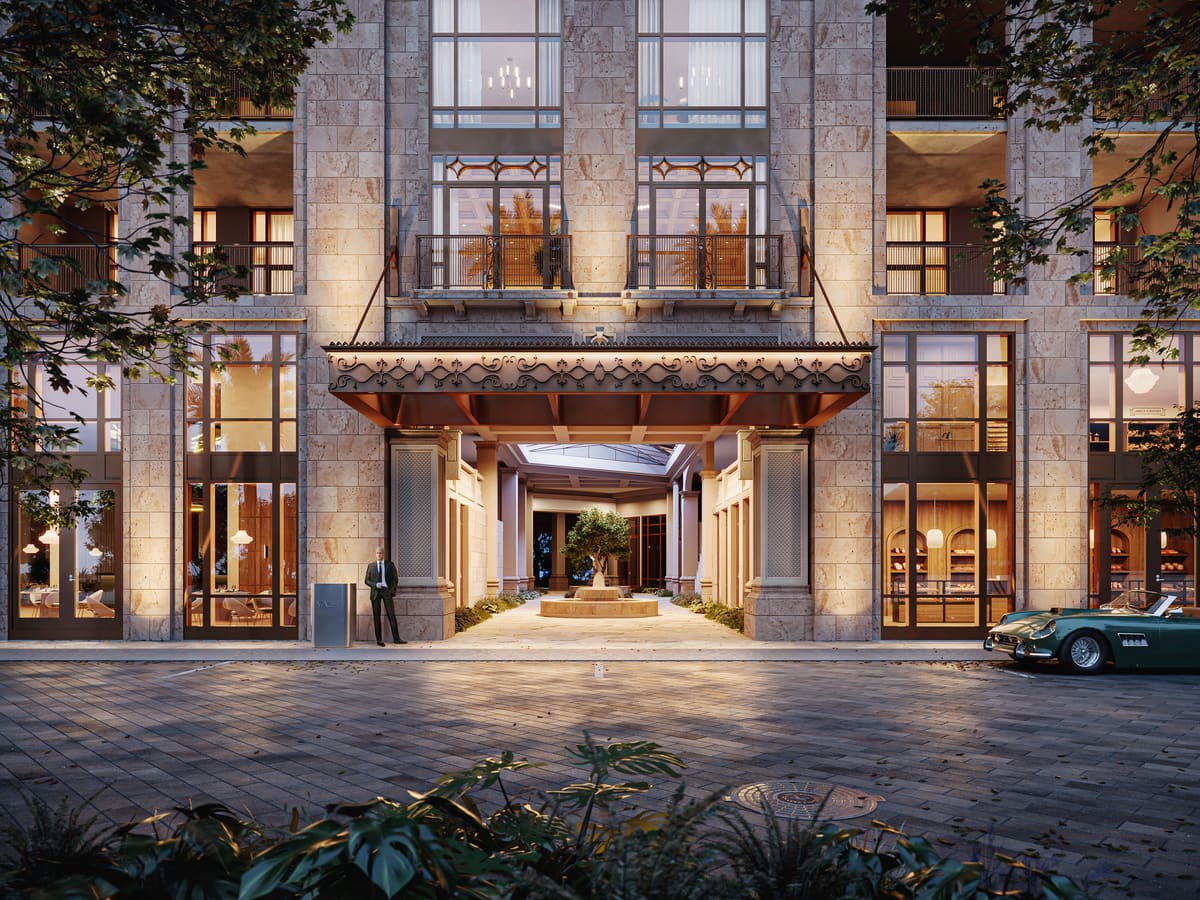The covered arrival court at Ponce Park Residences, framed by stone columns and a bronze canopy