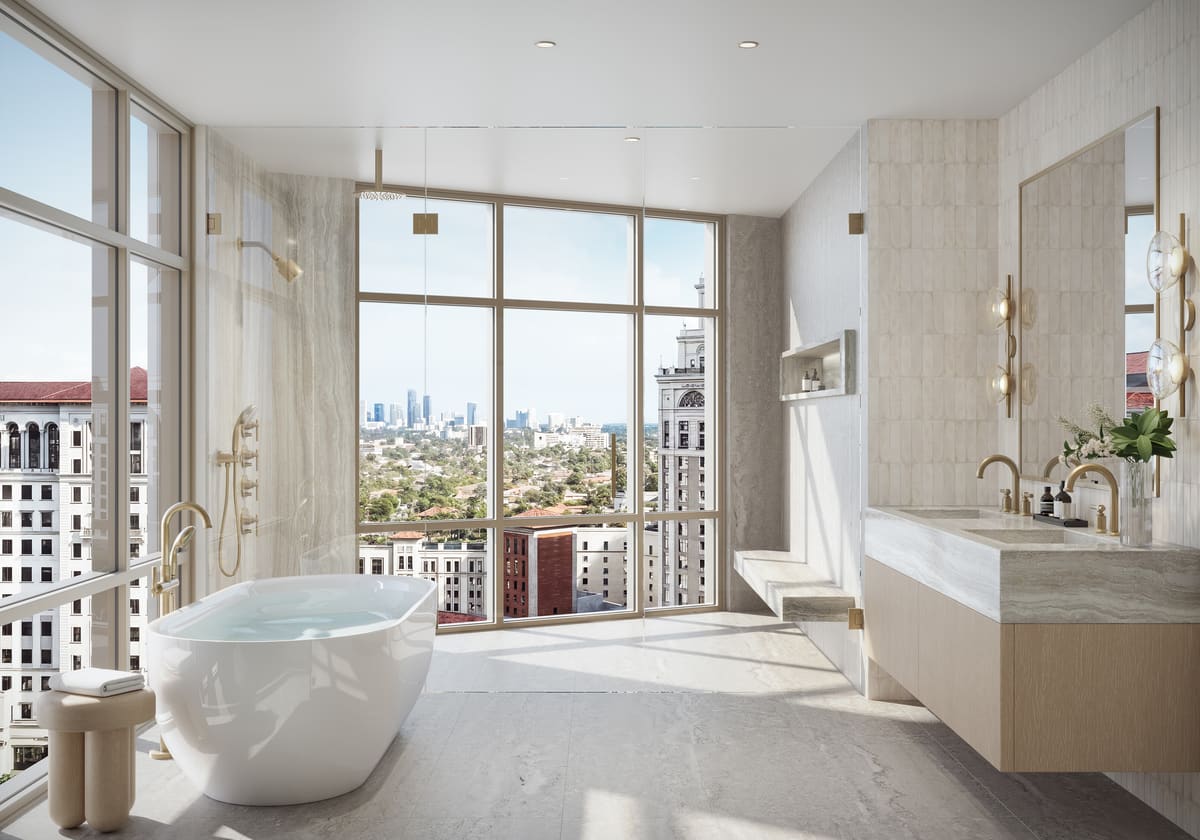 A primary bathroom at Ponce Park Residences, with a freestanding tub set against floor-to-ceiling glass