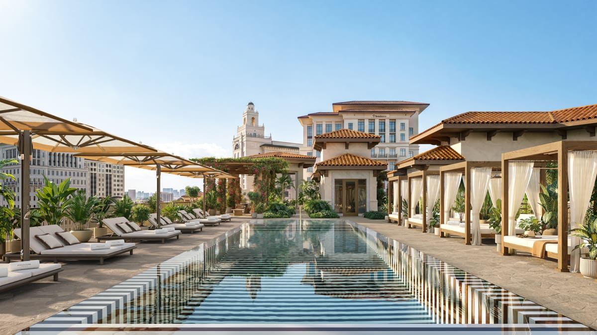 The rooftop lap pool at Ponce Park Residences, lined with cabanas and loungers above the Coral Gables skyline