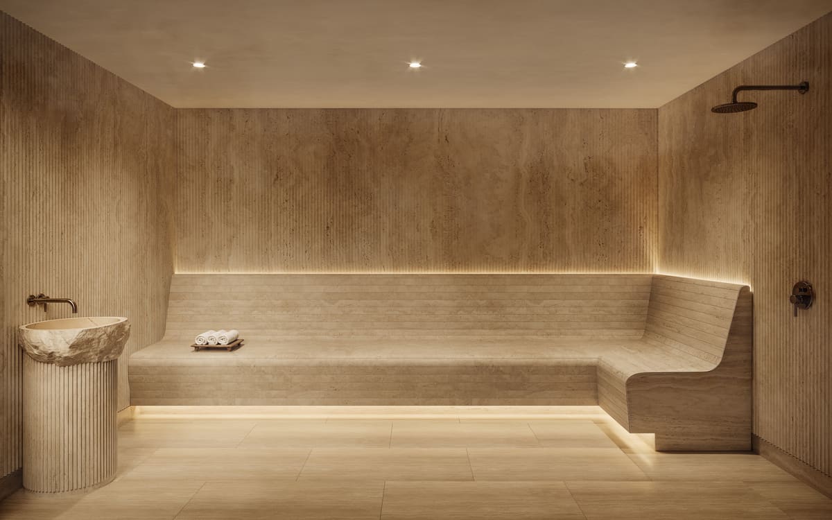 The stone steam room at Ponce Park Residences, with a carved basin and continuous bench